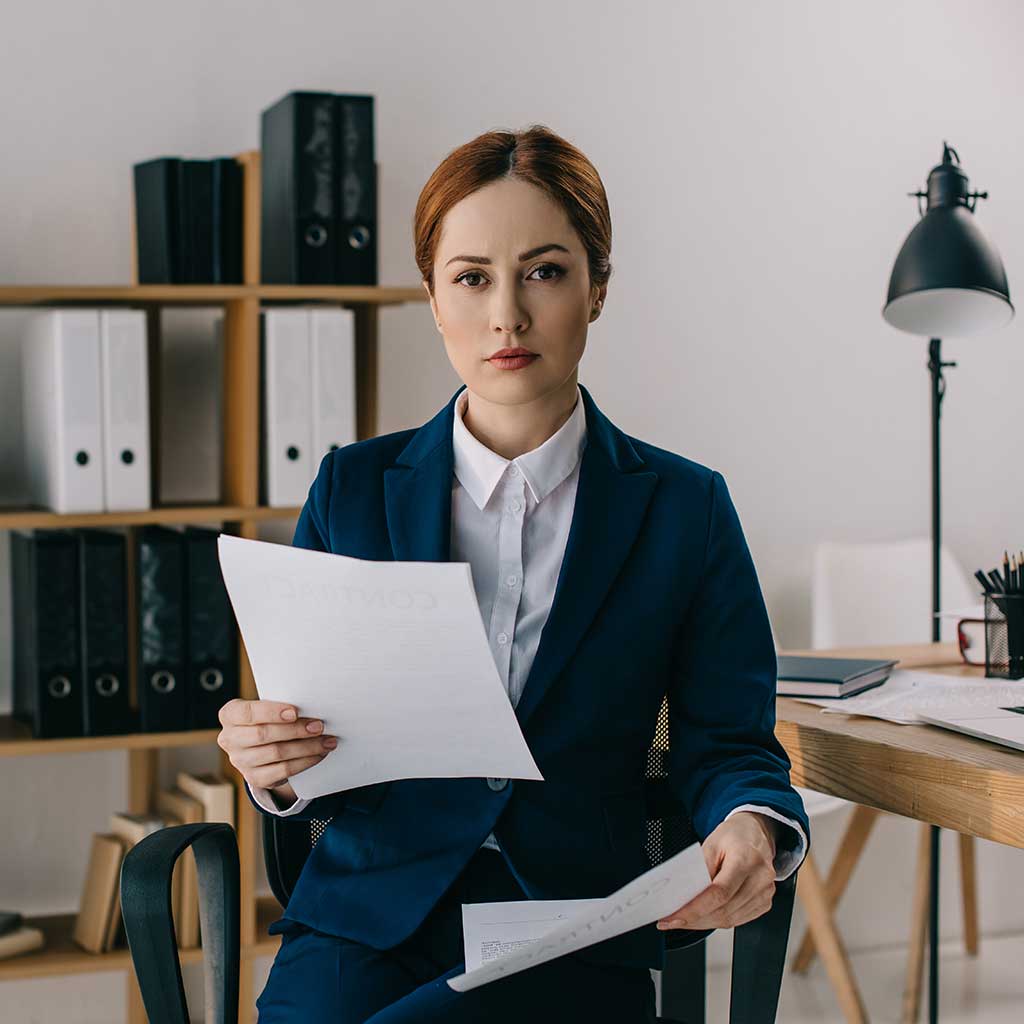 portrait-of-female-lawyer-in-suit-with-documents-i-AGD8X3M.jpg